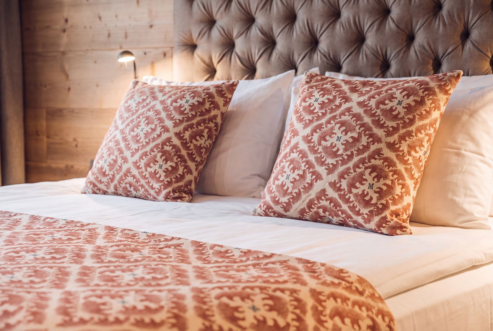 Bed dressed in the patterned throw and cushions